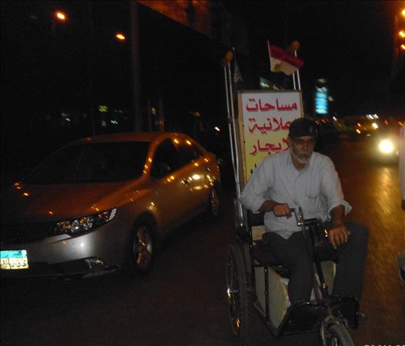 معاق يحوِّل دراجته للوحة إعلانية متجولة