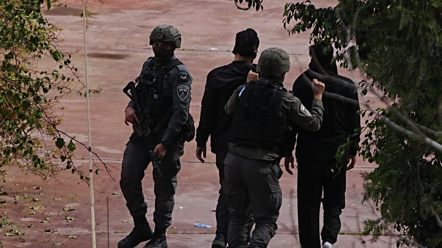 İsrail askerleri Batı Şeria'da bir Filistinliyi gözaltına alırken