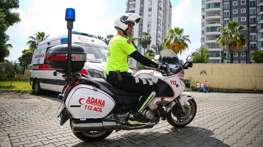 Adana'da bir motosikletli sağlık görevlisi hastaya müdahale ediyor.