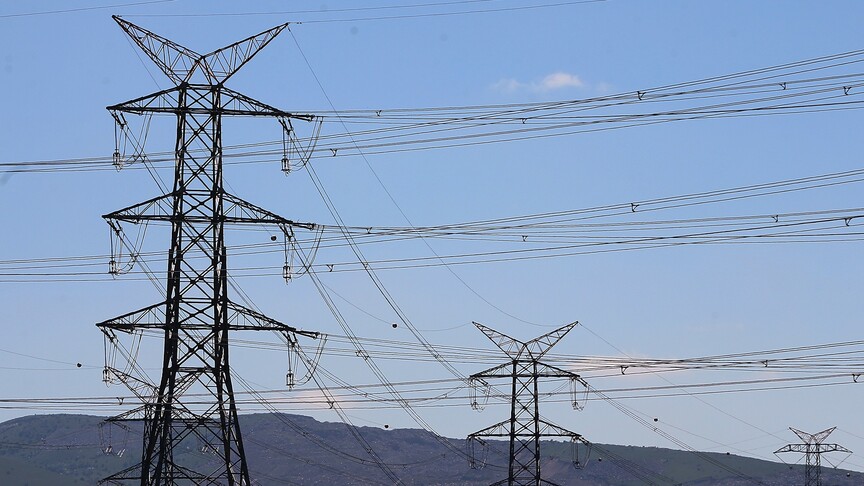 İran ve Katar bayrakları ve elektrik hatlarını temsil eden soyut bir görsel.