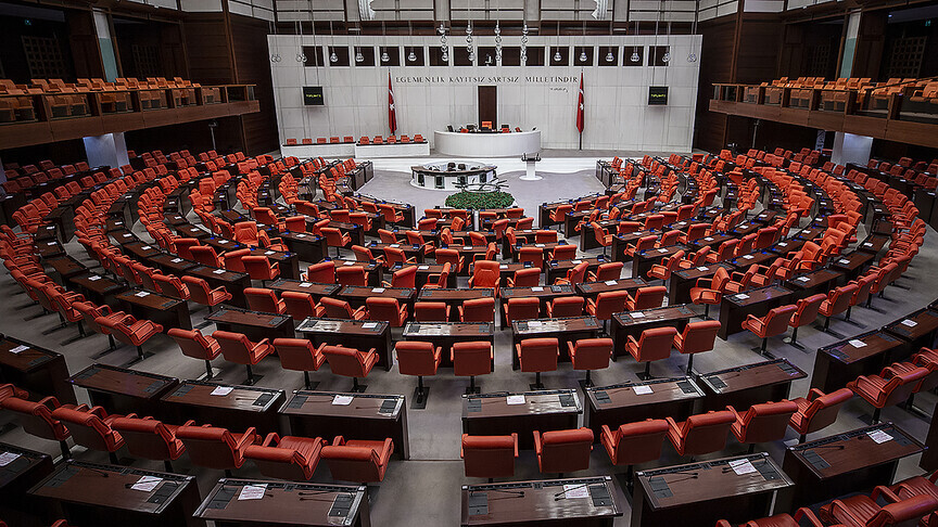 TBMM binası ve önünde duran adalet terazisi sembolü.