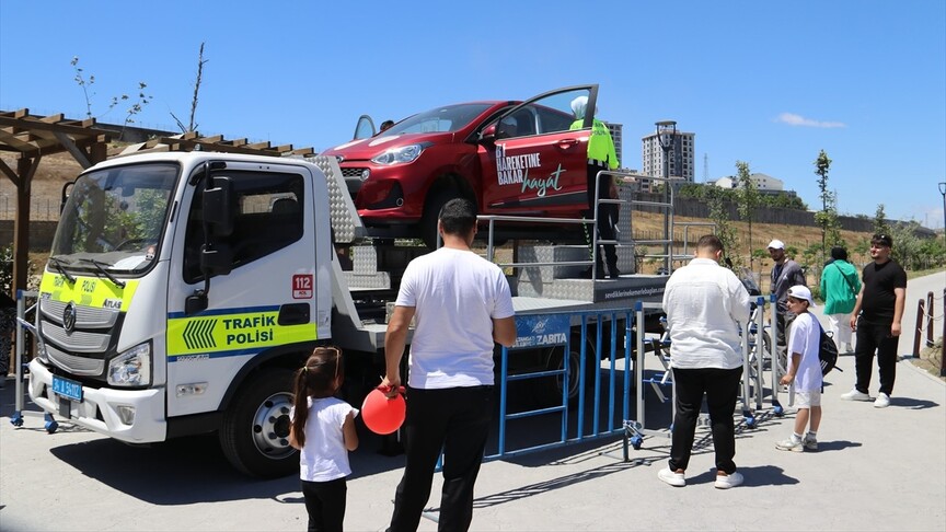 Vatandaşlar, İstanbul'da düzenlenen etkinlikte emniyet kemeri simülasyon aracını deneyimliyor.