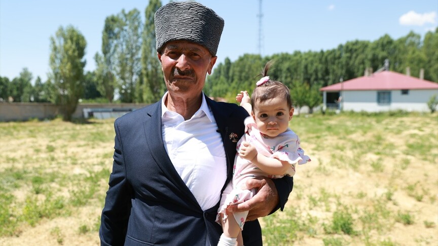 Kıbrıs Gazisi Abdulkadir Kurt, elinde Türk bayrağı ile asker selamı verirken.